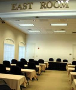 East Room, Tennessee Society Of Certified Public Accountants, Brentwood — Meeting room featuring mounted LCD projector, drop down screen and wall AV controls. 8ft skirted tables and black rolling adjustable chairs complement the room. New carpet throughout. Partition wall separates East Room from the West Room. Can (on dimmers) and incandescent lighting in the ceiling.