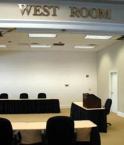 West Room, Tennessee Society Of Certified Public Accountants, Brentwood — Meeting room featuring mounted LCD projector, screen wall and wall AV controls. 8ft skirted tables and black rolling adjustable chairs complement the room. New carpet throughout. Partition wall separates East Room from the West Room. Windows to the front lawn feature blinds for privacy and light control. Can (on dimmers) and incandescent lighting in the ceiling.