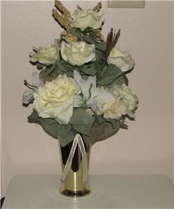 This is a one of a kind and unique Centerpiece. This can be used as a home decor or for your event tables. We used a fall colored bag with a lily print for this piece and we added a variety of flowers such as lilies, roses and daisies in browns, gold, white and soft yellow colors. The white and gold ribbon was added as a final touch. The bag is 7" wide by 9" tall and with the flowers the total height is 19" and the width is 17".