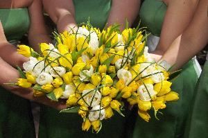 Little Black Dress Brigade, Little Rock — Just a sample of the many bridesmaid bouquets we've created.  This one uses white and yellow tulips and sassy strips of bear grass.  The bride gave each girl a "lucky clover" pin to top off the Irish theme of the event and we pinned the clover onto the hand tied chocolate brown ribbon.