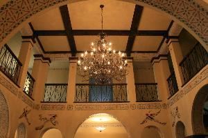1929 Hotel Seville, Harrison — a grand lobby is adorned with a grand chandelier as overlooked by a surrounding mezzanine