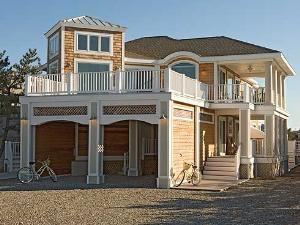 The Sunset House, Resort Pointe, Fenwick Island — The best of both worlds! Built in 2005 on the narrow barrier island of Fenwick, this sumptuous, multimillion-dollar home sits on the bay, but is located just two blocks from the ocean. Enjoy spectacular views of the bay from three sides of the house. Bring your own boat or paddle off from the private dock in one of the new kayaks. Swim in the ocean all day and return to the heated pool for a dip before dinner. Rental of this fabulous property includes two permits for parking 40 feet from the beach, plus the use of three kayaks and two beach bikes.