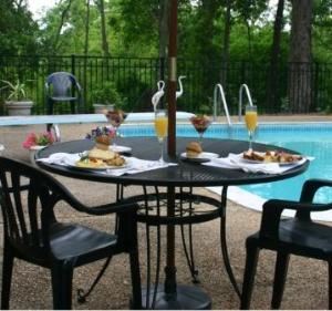 Pool Area, Bryn Rose Inn, Vicksburg — The pool area at Bryn Rose Inn has umbrellas, tables, chairs and chaise for relaxing.  Surrounded by woods and roses, the pool area provides a cool retreat.