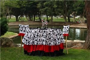 Bella Event Services, Costa Mesa — white and black ribboned taffeta overlay withe two layered satin linens (red and black), matching chair caps,