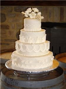 Elizabethan Delights, Charlotte — Roses and grapes adorn this wedding cake.  Elaborately piped detail in a Victorian style.