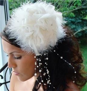 Fairytale Bridal Tiara, Miami — This vintage-inspired bridal hat is an enchanting alternative to a bridal veil. The piece features a feather base with a bow and three fabric roses on top. Faux pearls and rhinestones subtly sit at the center of the roses, and a spray of faux pearls dangle beautifully off of one side.