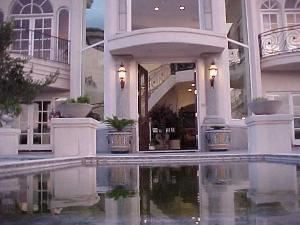 Mediterranean Mansion, Rancho Valle Milagro, Tucson — Walking up the stairs to the entrance, you pass by a negative edge pool with colored backlit water flowing over the edge.
