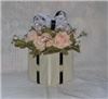 Enchanted Decorating Designs, Tampa — This beautiful centerpiece measures 11”H x 9.5”W. It consists of six open pink & cream roses, baby’s breath and greenery together with an infusion of a colored bow eloquently placed on a 5” square foam block covered in ivory/cream paper. ½” black satin ribbon runs on each side of the block to give it that classic look. These centerpieces comes in an array of colors so call or email us with your order in quantity and colors. Please visit our website at www.enchanteddecoratingdesigns.com for our full selection.