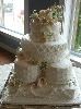 All OURS Catering, Charlotte — A gorgeous detailed 4 layer Wedding Cake. Seven layers come together to make this customized cake. Several designs can be incorporated to produce the ideal cake for each Brides Dream Cake. The flowers on this cake are all hand sculpted from rich white chocolate clay. Detail is the key, the corneli lace continues to the cake board to create continuity in the design. View our website for more impressive cakes.