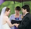 A Wedding Minister, Raleigh — Jenn and Brandon married on the dock at scenic Lake Johnson. During the ceremony it started sprinkling rain. All of a sudden we were surrounded and covered by pretty lavender umbrellas. It was a memorable and lovely wedding!