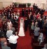 A Wedding Minister, Raleigh — Tara and Andy got married at Long View Center in Raleigh. It is such a beautiful setting for a wedding. In this photo, Tara and her father "float" down the aisle to the wedding party, Andy and me who are awaiting her as the guests stand in her honor. The transfer of hands is made and then we all step up to the top of the altar for the ceremony--symbolic of raising their relationship to a higher level. It was a gorgeous wedding!