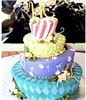 Goehrig's Bakery, Jersey City — A whimsical topsy turvy cake with great use of color. Mosaic patterns start the bottom tier and finish with vertical candy striping. A great cake for fantasy inspired events.