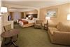 Best Western Ambassador Suites, Venice — 2 Queen Bed Suite with flat screen television.  Sofa, chair, eating table in sitting area.  Kitchenette has refrigerator, microwave and coffee maker.