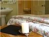 The Brewster Inn, Dexter — The Strawberry Room  -  Good things DO come in small packages! 

Sweetly decorated, this petite former maid's room is full of historic charm as it still retains much of its original detail and woodwork. 

The queen size bed is surrounded by a delicate strawberry & flower wallpaper. Relax with an evening movie on the television; curl up with a home-made afghan. A pretty pedestal sink stands in the main room. Two smaller rooms accommodate the stand-up shower and water closet.