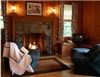 The Brewster Inn, Dexter — The Game Room  -  You'll feel like you're spending the night in a Swiss chalet! 

Truly a grand room with king size bed and comfortable seating in front of the cozy fireplace. Our family inspired Game Room delights guests of all ages with its generous size and rustic charm. 

The table seats four and works well for games, late night snacking or morning coffee. Extra guests and/or children are accommodated with a comfy antique 3/4 iron bed. 

The private ensuite bathroom has a shower.