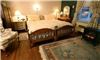 The Brewster Inn, Dexter — The Garden Room - This generous and cheerful corner room features many windows with wonderful views out over the Brewster Inn gardens. A king size bed (which can be converted into two twin size beds) and twin daybed with trundle make it a pleasant and spacious room for traveling companions. It is especially suitable for families or girlfriend getaways. Watch television or read in the comfortable wingback chair. 
Curl up with a hand-made afghan on chilly nights. Ladies will enjoy the added luxury of an antique art deco style dressing table. The petite bathroom has a shower.