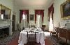 Homewood House Museum, Baltimore — Dining Room

Charles Carroll, Jr. ordered a "crimson and drab carpet" for his dining room and this reference, found in the Carroll papers, is the basis for the Dining Room's Brussels carpet. A "crumb cloth" protects the carpet (which would have been very expensive) from spilled food and wear and tear. The table is set with imported English silver, ceramics, and glassware. The freestanding columns along the chimneypiece are an elegant and unusual architectural feature.