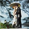 Lovely Wedding Store, Fremont — Showered with Love Couple Figurine -- A beautiful dress, a stylish suit, one white umbrella and a great pair of rubber boots all combine to create this very adorable cake topper. Some believe that rain on a wedding day will bring good luck. Regardless, rain or shine, this delightful cake decoration is sure to stand out for all the right reasons. Hand painted porcelain. The couple is 16 cm Tall

Dimension: 2 3/8" x 2 3/8" x 6 1/4" H