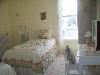 The Gathering Place, Sioux Falls — The "Rachel" room is done in shabby chic decor. This bedroom has two twin beds and a dressing table with stool.