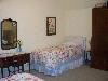 The Gathering Place, Sioux Falls — The "Alicia" room is complete with two twin beds, armore, and dressing table with mirror and stool. Enjoy high quality beds and linens in all rooms.