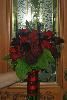 Flowers by Mary Beth Bartel, Portland — 1920's style bridal bouquet: a medley of red roses, fern frons, black feathers and greenery.